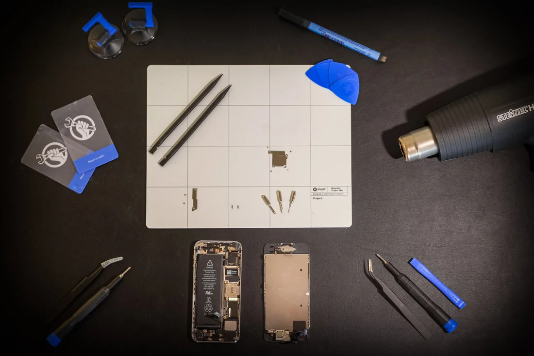 Device repair tools and an opened smartphone on a workbench